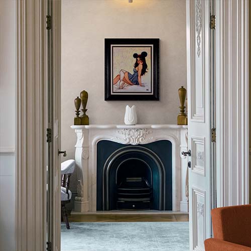 fireplace with framed artwork hanging above it
